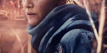 Close-up of a woman in a blue jacket and scarf standing on a sunlit street; the poster text at the bottom reads 'MARE of EASTTOWN'