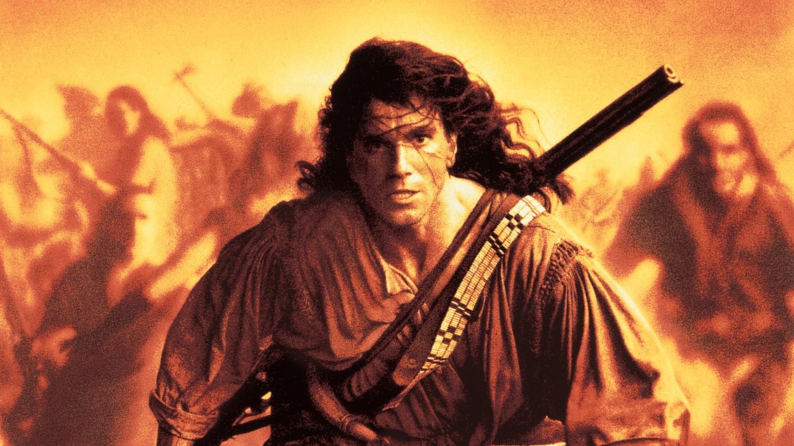 John Rambo-style action hero runs forward with a rifle strapped across his chest, amid a blazing, orange-tinted battlefield background.
